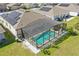 Aerial view of a house with a screened-in pool and solar panels at 588 Hitch Loop, St Cloud, FL 34769