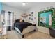 A room with a gray carpet, a bed covered in black velvet, and a mirror decorated with flowers at 588 Hitch Loop, St Cloud, FL 34769