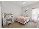 Bright bedroom with a pink bedspread, a vanity table with lighting, and a large 'C' on the wall at 588 Hitch Loop, St Cloud, FL 34769