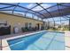 Relaxing screened-in pool area with comfortable seating and a barbecue grill, perfect for outdoor entertaining at 588 Hitch Loop, St Cloud, FL 34769