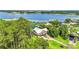 Aerial view of a waterfront home surrounded by lush greenery and a lake at 6375 Topsy Trl, St Cloud, FL 34771
