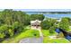 Aerial view of a waterfront home surrounded by lush greenery and a lake at 6375 Topsy Trl, St Cloud, FL 34771