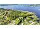 Aerial view of a waterfront home surrounded by lush greenery and a lake at 6375 Topsy Trl, St Cloud, FL 34771