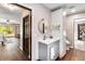 Bathroom vanity with round mirror and cabinet, plus view to bedroom and workout room at 6375 Topsy Trl, St Cloud, FL 34771
