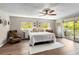 Bright bedroom with hardwood floors, multiple windows, a ceiling fan, and access to a private balcony at 6375 Topsy Trl, St Cloud, FL 34771