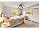 Cozy bedroom featuring a colorful bedspread, side tables, and large windows at 6375 Topsy Trl, St Cloud, FL 34771