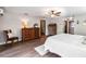 Spacious bedroom with hardwood floors, ceiling fan, dresser, and cozy sitting chair at 6375 Topsy Trl, St Cloud, FL 34771