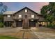 A two-story house with a metal roof, dark siding, a two-car garage, and a staircase leading to the front door at 6375 Topsy Trl, St Cloud, FL 34771