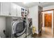 Well-equipped laundry room with washer, dryer, and ample storage cabinets at 6375 Topsy Trl, St Cloud, FL 34771