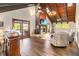 Living room showcasing stone fireplace, hardwood floors, wood vaulted ceilings, and natural light at 6375 Topsy Trl, St Cloud, FL 34771