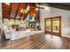 Inviting living room with wood vaulted ceilings, hardwood floors, stone fireplace, and patio access at 6375 Topsy Trl, St Cloud, FL 34771