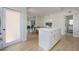 White kitchen island overlooking a dining area with decorative paintings and light wood floors at 712 Maryland Ave, St Cloud, FL 34769