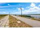 Scenic walking path with benches along the water under a bright blue sky with puffy clouds at 712 Maryland Ave, St Cloud, FL 34769