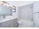 Bright bathroom featuring marble tile, a tub with shower and a gray vanity at 713 Coach Light Dr, Fern Park, FL 32730