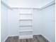Walk-in closet featuring a custom shelving unit and wood look flooring at 713 Coach Light Dr, Fern Park, FL 32730