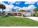 Charming single-story home with a well-manicured lawn, brick accents, red front door, and attached garage at 713 Coach Light Dr, Fern Park, FL 32730
