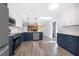 Modern kitchen featuring two-tone cabinets, stainless steel appliances, quartz countertops, and wood-look flooring at 713 Coach Light Dr, Fern Park, FL 32730