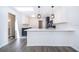 Modern kitchen with white cabinets, blue accents, gray wood-look flooring, and a large island at 713 Coach Light Dr, Fern Park, FL 32730