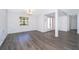 Neutral living room with gray wood-look flooring and bright natural light streaming in from the window at 713 Coach Light Dr, Fern Park, FL 32730