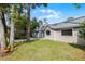 Backyard with lush green grass, garden, and a greenhouse at 717 Pine Ter, Altamonte Springs, FL 32714