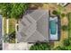 Aerial view of a private backyard with screened pool and spa surrounded by mature trees at 7978 Sea Pearl Cir, Kissimmee, FL 34747