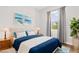 Bright bedroom with coastal decor features light hardwood floors, a large window, and coordinated furniture and artwork at 7978 Sea Pearl Cir, Kissimmee, FL 34747