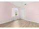 Bright bedroom with light wood floors, pink walls, closet, and a window for natural light at 7978 Sea Pearl Cir, Kissimmee, FL 34747