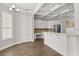 Well-lit kitchen with white cabinetry, a long peninsula for bar seating, a coffered ceiling and wood-look floors at 7978 Sea Pearl Cir, Kissimmee, FL 34747
