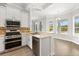 Bright kitchen boasts white cabinetry, stainless steel appliances, and a breakfast bar with views of the backyard at 7978 Sea Pearl Cir, Kissimmee, FL 34747