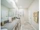 Bright bathroom featuring dual sinks, a large mirror, neutral paint, and a walk-in shower with glass door at 8907 Fallen Oak, Davenport, FL 33897