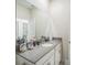 Modern bathroom featuring large mirror, single sink with stone countertop, and white cabinets at 8907 Fallen Oak, Davenport, FL 33897