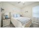 Well-lit bedroom with neutral walls, coastal decor, and a white wooden bed frame at 8907 Fallen Oak, Davenport, FL 33897