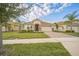 Charming single-story home featuring a well-manicured lawn, brick driveway, and a tile roof at 8907 Fallen Oak, Davenport, FL 33897