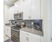 Modern kitchen boasts stainless steel appliances, including an oven and microwave, set against a gray tiled backsplash at 8907 Fallen Oak, Davenport, FL 33897
