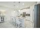 Bright modern kitchen featuring white cabinets, stainless steel appliances, and center island with barstool seating at 8907 Fallen Oak, Davenport, FL 33897
