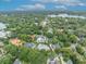 Expansive aerial view of a lush, green neighborhood with serene lake views under a partly cloudy sky at 940 Lincoln Cir, Winter Park, FL 32789
