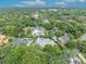 Aerial neighborhood scene with upscale homes, swimming pools, a serene lake, and verdant landscaping at 940 Lincoln Cir, Winter Park, FL 32789