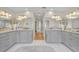Bathroom featuring dual vanities, walk-in shower and tiled flooring with central hallway at 940 Lincoln Cir, Winter Park, FL 32789