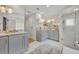 Bathroom featuring dual vanities, walk-in shower with glass door and tiled flooring at 940 Lincoln Cir, Winter Park, FL 32789