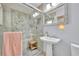 Bathroom featuring a walk-in glass shower, pedestal sink, and decorative mirror at 940 Lincoln Cir, Winter Park, FL 32789