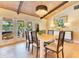 Dining area with seating for six, wood floors, chandelier, and views to the outside at 940 Lincoln Cir, Winter Park, FL 32789
