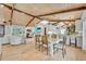Open concept dining area featuring wood-beamed ceilings and hardwood floors with view of the living room and kitchen at 940 Lincoln Cir, Winter Park, FL 32789