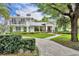 Beautiful two-story house showcasing manicured landscaping, balcony, and curved brick path at 940 Lincoln Cir, Winter Park, FL 32789
