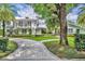 Stunning two-story home with a beautifully landscaped yard and a curved brick driveway at 940 Lincoln Cir, Winter Park, FL 32789