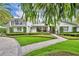 Attractive two-story home showcasing manicured landscaping, balcony, and curved brick path at 940 Lincoln Cir, Winter Park, FL 32789