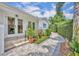 Professionally landscaped walkway to the side entrance of the home with colorful flower beds at 940 Lincoln Cir, Winter Park, FL 32789