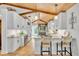 Bright kitchen with white cabinets, tiled backsplash, granite counters, and adjacent breakfast bar with straw stools at 940 Lincoln Cir, Winter Park, FL 32789