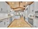Bright open kitchen with an island bar, wooden ceiling beams, and stainless steel appliances at 940 Lincoln Cir, Winter Park, FL 32789