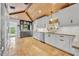 Bright kitchen with tan tile floors, white cabinets, wood ceiling and a kitchen island at 940 Lincoln Cir, Winter Park, FL 32789