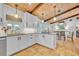 Bright modern kitchen with white cabinets, wooden ceiling beams, and an island bar at 940 Lincoln Cir, Winter Park, FL 32789